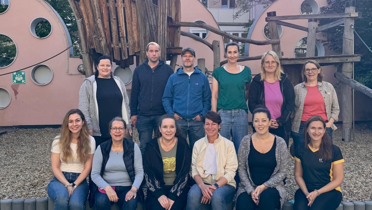 Gruppenbild von 15 Mitarbeiter:innen der Wirtschaftsprüfung EY