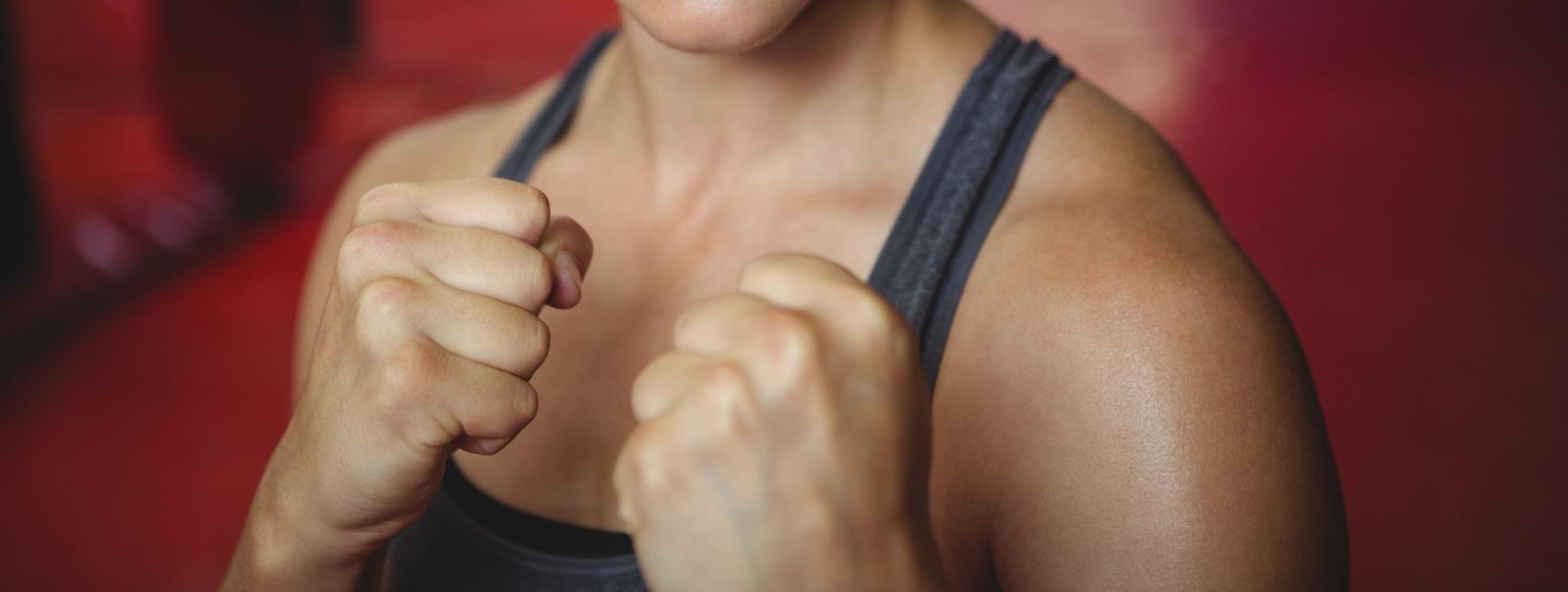 zuversichtlich-weiblicher-boxer-der-boxhaltung-durchfuhrt