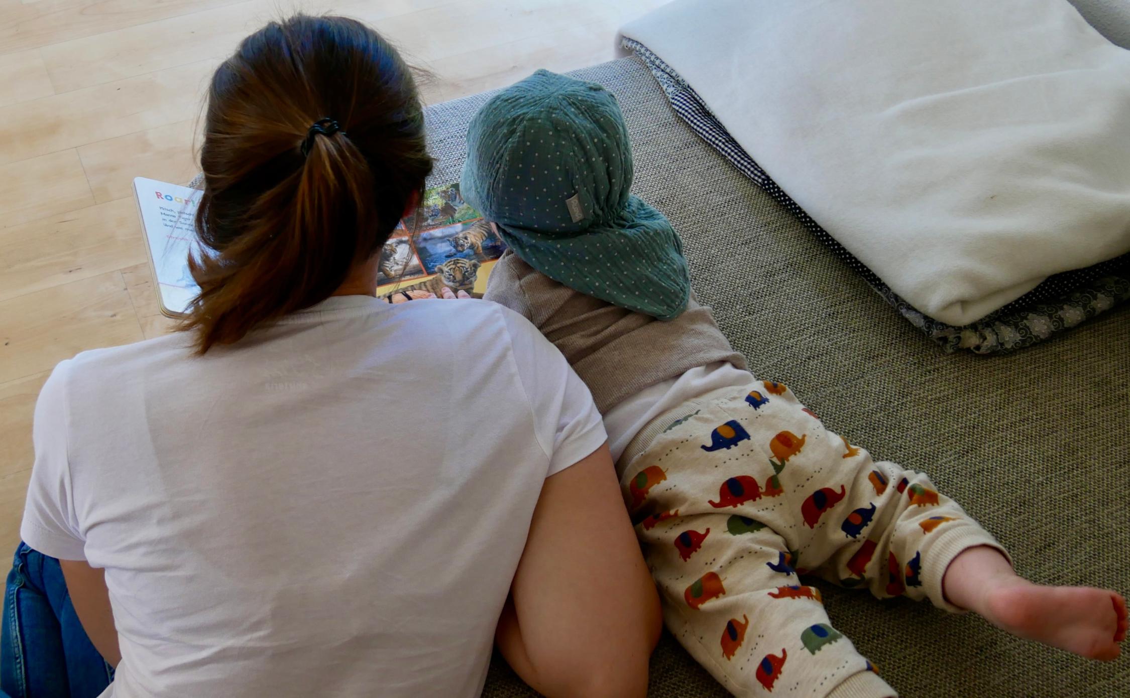 Mutter und Baby beim Buch anschauen (c) SkF Familienzentrum Monikahaus – Frankfurt am Main Mutter und Baby beim Buch anschauen