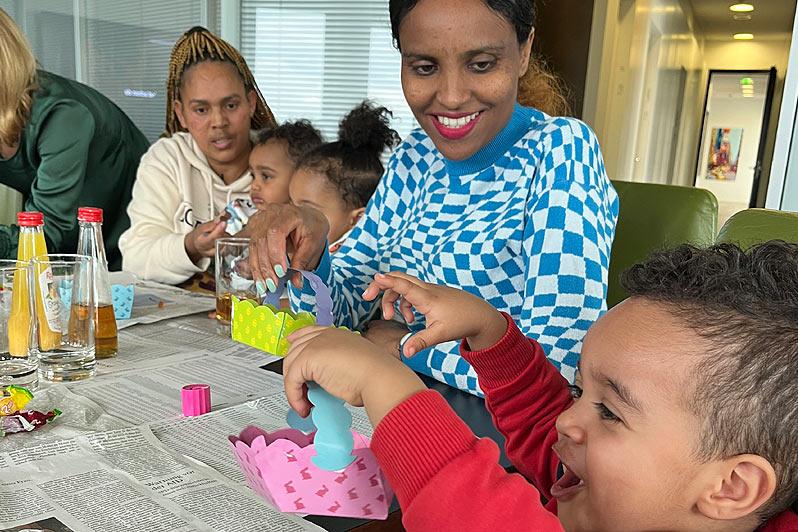 Eine Gruppe aus Frauen und Kindern sitzt um einen Tisch